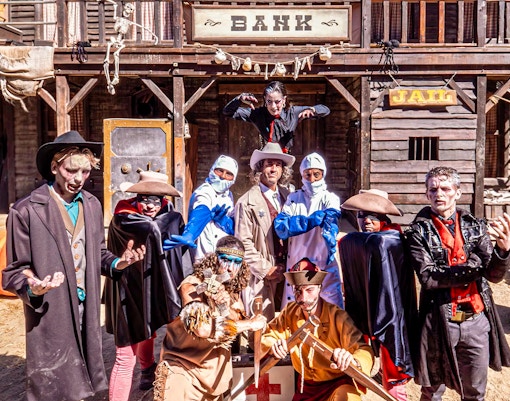 Port Aventura's West Blood Frenzy show with performers in cowboy attire on stage.