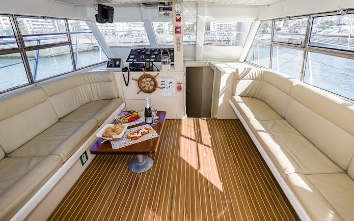 Interior of a yacht with food and drinks on a table during Whale and Dolphin Watching in Tenerife.