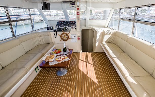 Interior of a yacht with food and drinks on a table during Whale and Dolphin Watching in Tenerife.