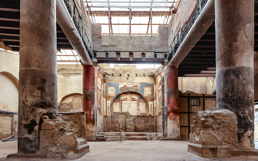Ruins of the College of the Augustales with frescoes and columns in Herculaneum, Italy.