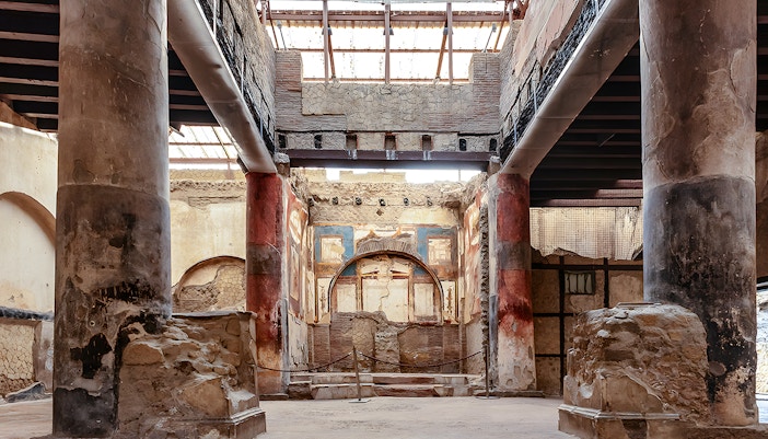 Ruins of the College of the Augustales with frescoes and columns in Herculaneum, Italy.