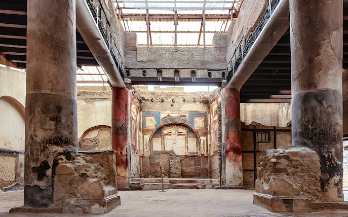 Ruins of the College of the Augustales with frescoes and columns in Herculaneum, Italy.