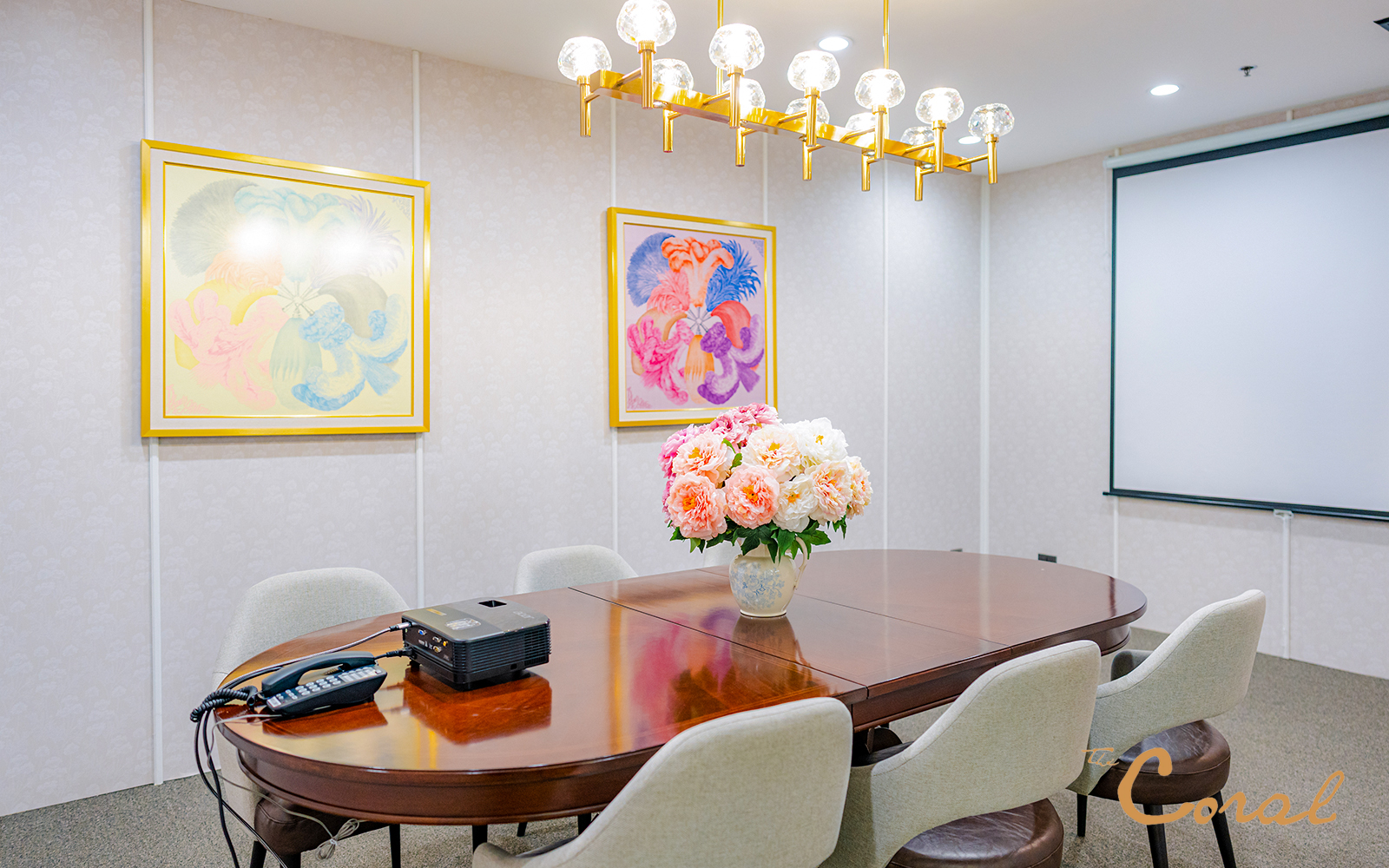 Meeting room with floral centerpiece and projector at Coral Finest Business Class Lounge, Bangkok airport.
