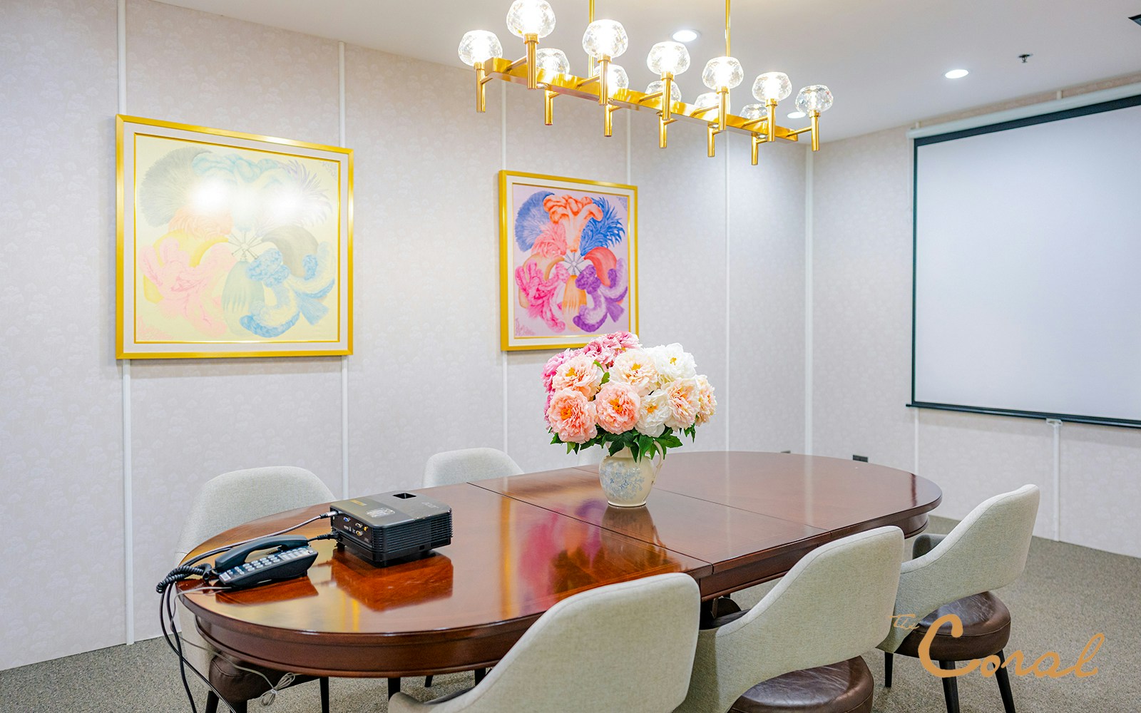 Meeting room with floral centerpiece and projector at Coral Finest Business Class Lounge, Bangkok airport.