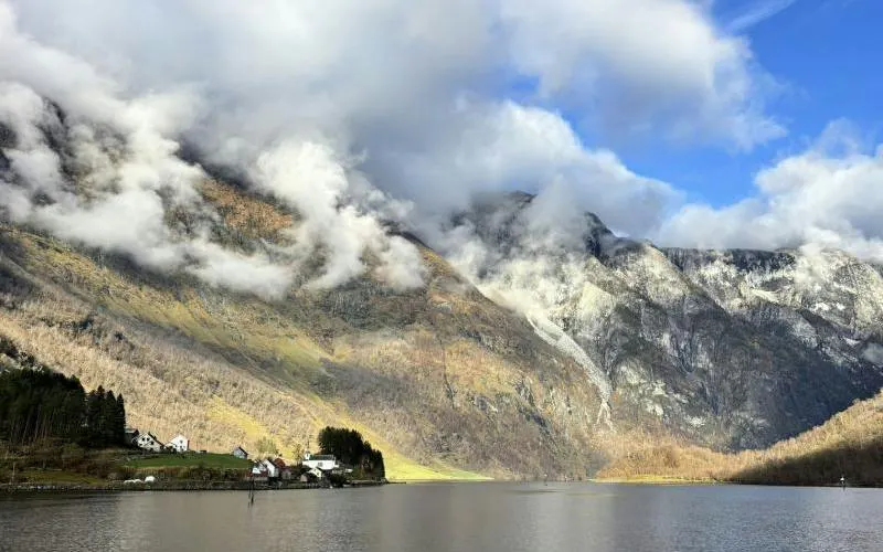 Bergen to Flåm Railway view of Nærøyfjord with mountains and village houses.