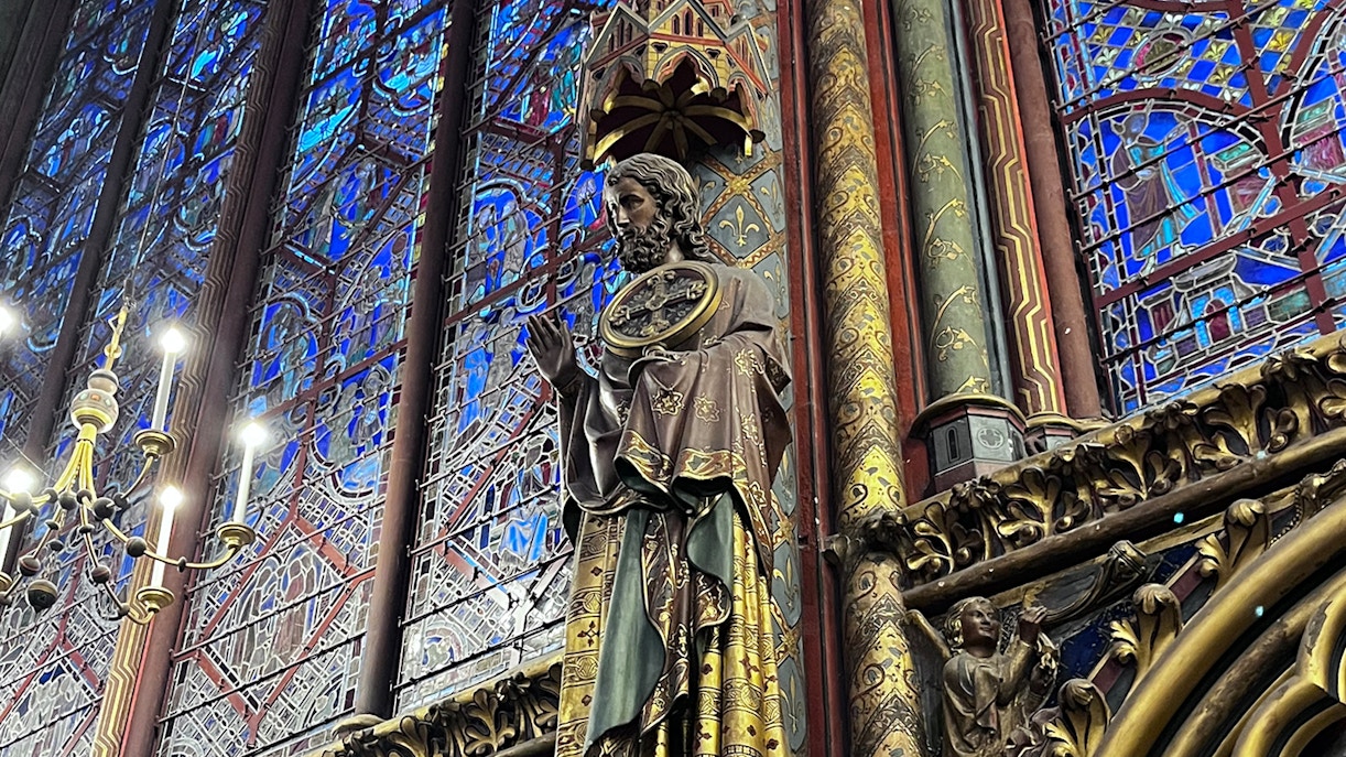 Sainte Chapelle interior with stained glass windows and statue.