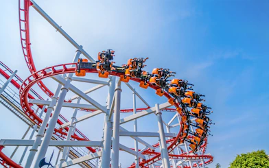 Roller coaster loop at Dream World Bangkok against blue sky.