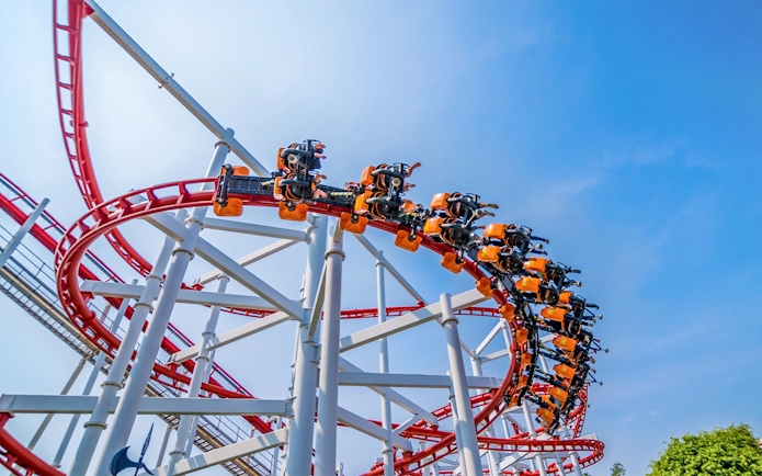 Roller coaster loop at Dream World Bangkok against blue sky.