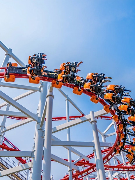 Roller coaster loop at Dream World Bangkok against blue sky.