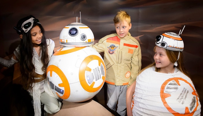 Children interacting with BB-8 droid at Star Wars exhibit.