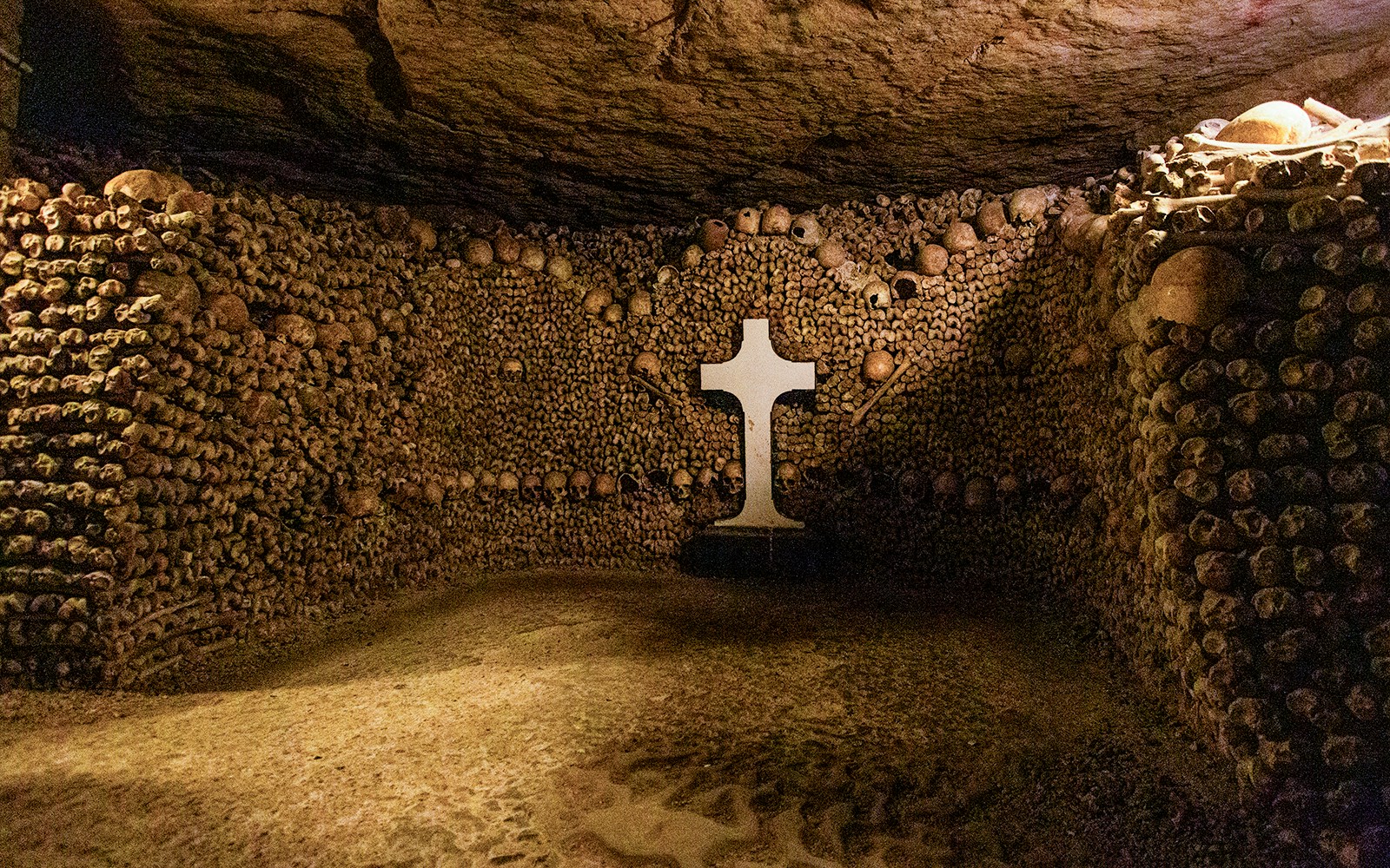 Christian symbols on walls in Paris Catacombs during guided tour with special access.