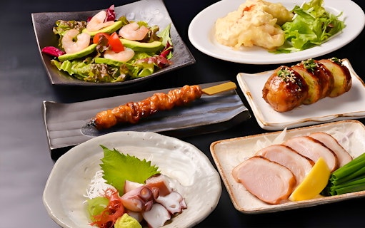 Traditional Japanese dishes including yakitori, sashimi, and salad at Hakata Dojo Ueno.