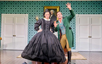 Actors in period costumes performing a scene from "Oh Mary!" in a vintage room setting.