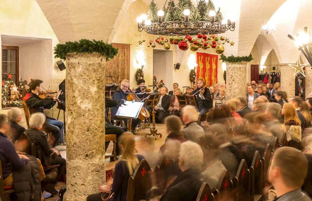 Musicians performing at Fortress Hohensalzburg Christmas Advent concert with audience seated.
