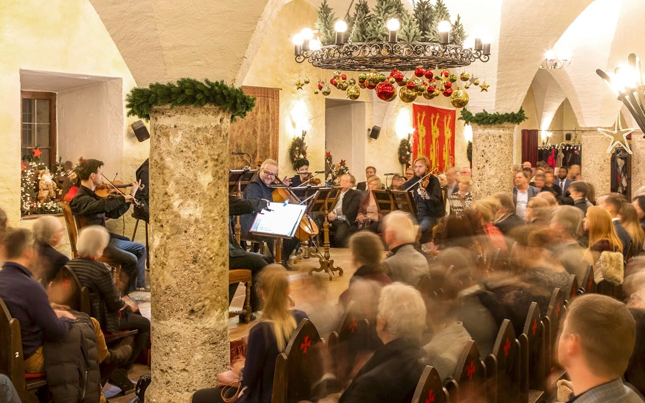 Musicians performing at Fortress Hohensalzburg Christmas Advent concert with audience seated.