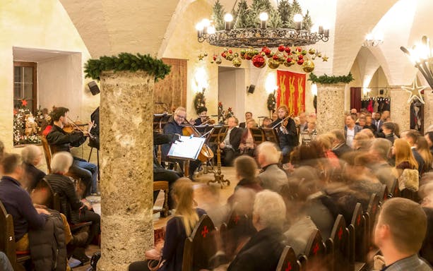 Musicians performing at Fortress Hohensalzburg Christmas Advent concert with audience seated.