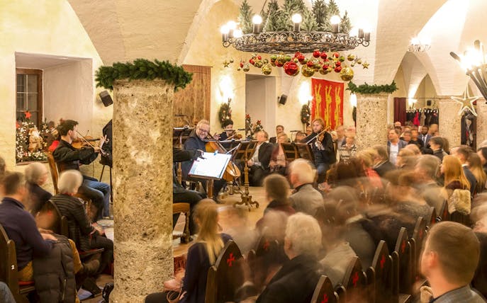Musicians performing at Fortress Hohensalzburg Christmas Advent concert with audience seated.