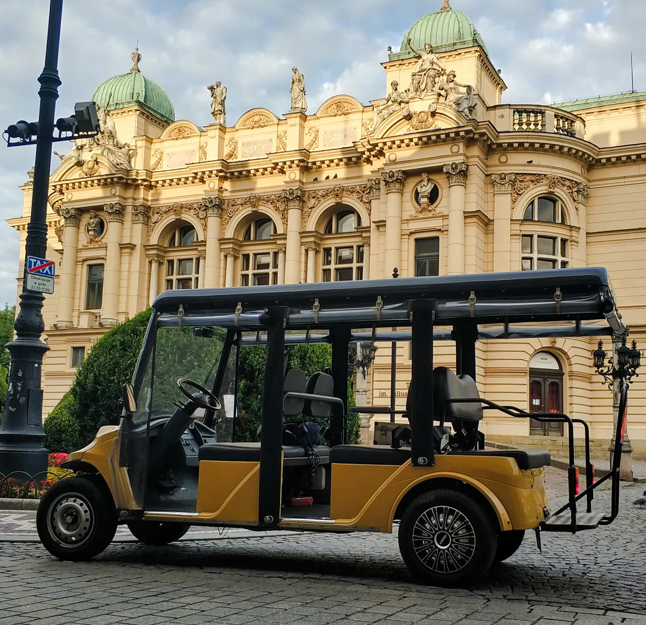 Golf cart in front of Krakow's historic building on Old Town tour.