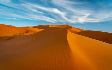 Sand dunes under blue sky in Sahara Desert, Morocco.