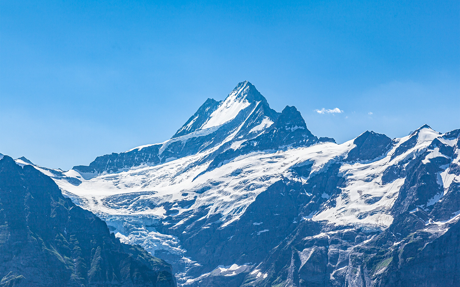 Snow-covered peaks of Jungfraujoch in the Swiss Alps under a clear blue sky.