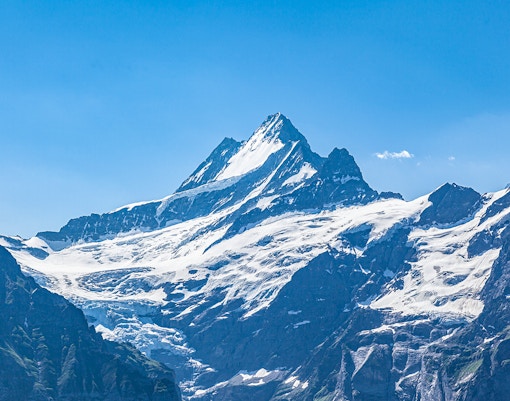 Snow-covered peaks of Jungfraujoch in the Swiss Alps under a clear blue sky.