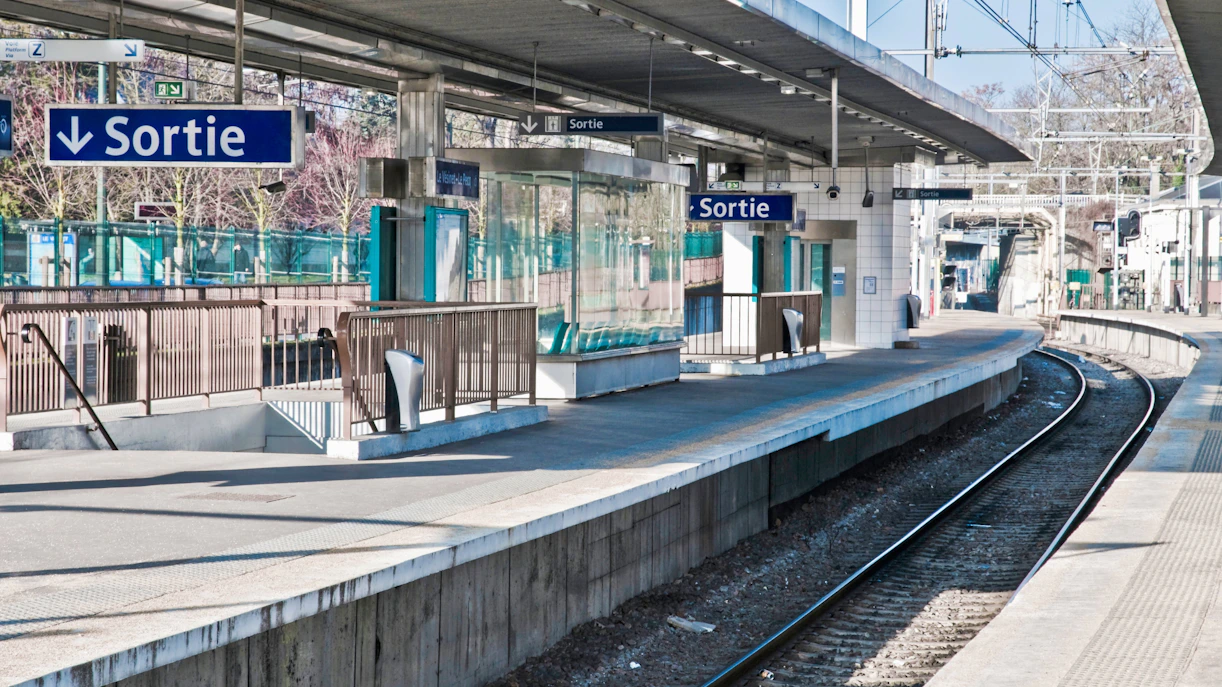 RER train platform in Paris, France, with signs for Disneyland Paris route.