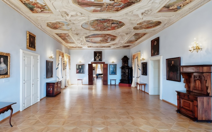 Lobkowicz Palace Museum interior with ornate ceiling and historical paintings, Prague.