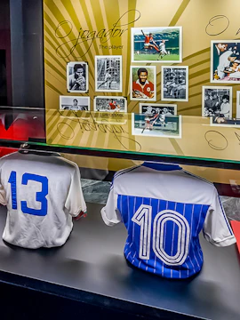 Benfica Museum display with historic football jerseys and player photos.
