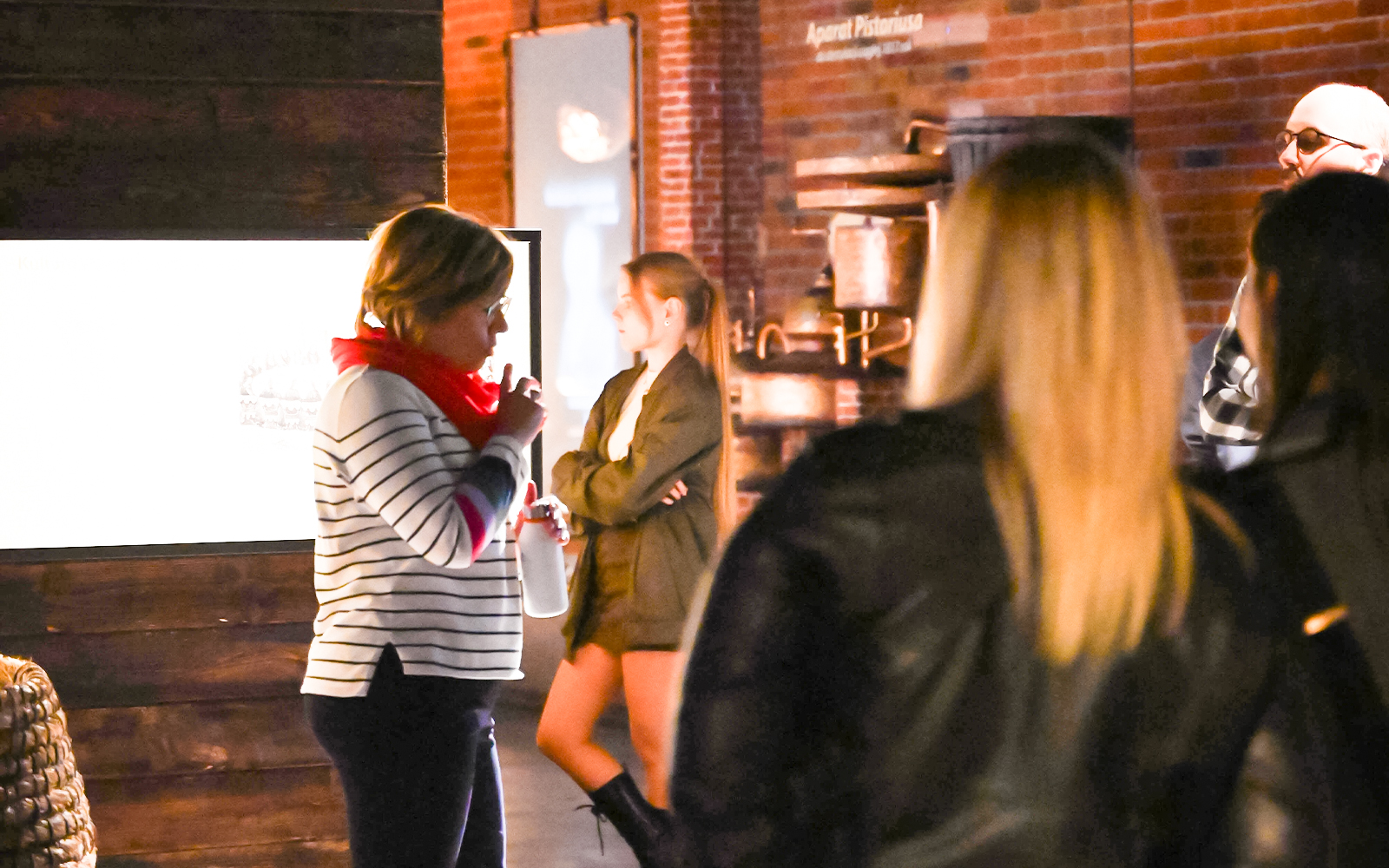 Visitors exploring exhibits at a vodka factory museum in Krakow.