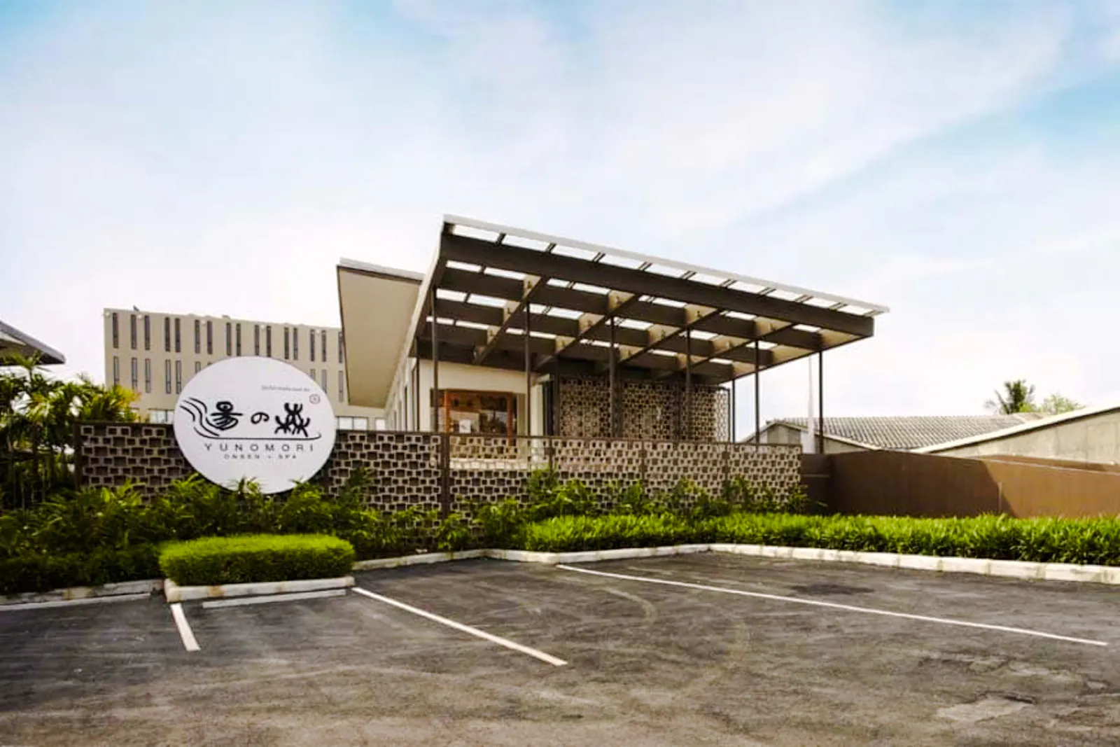 Yunomori Onsen & Spa entrance in Pattaya, featuring modern architecture and signage.