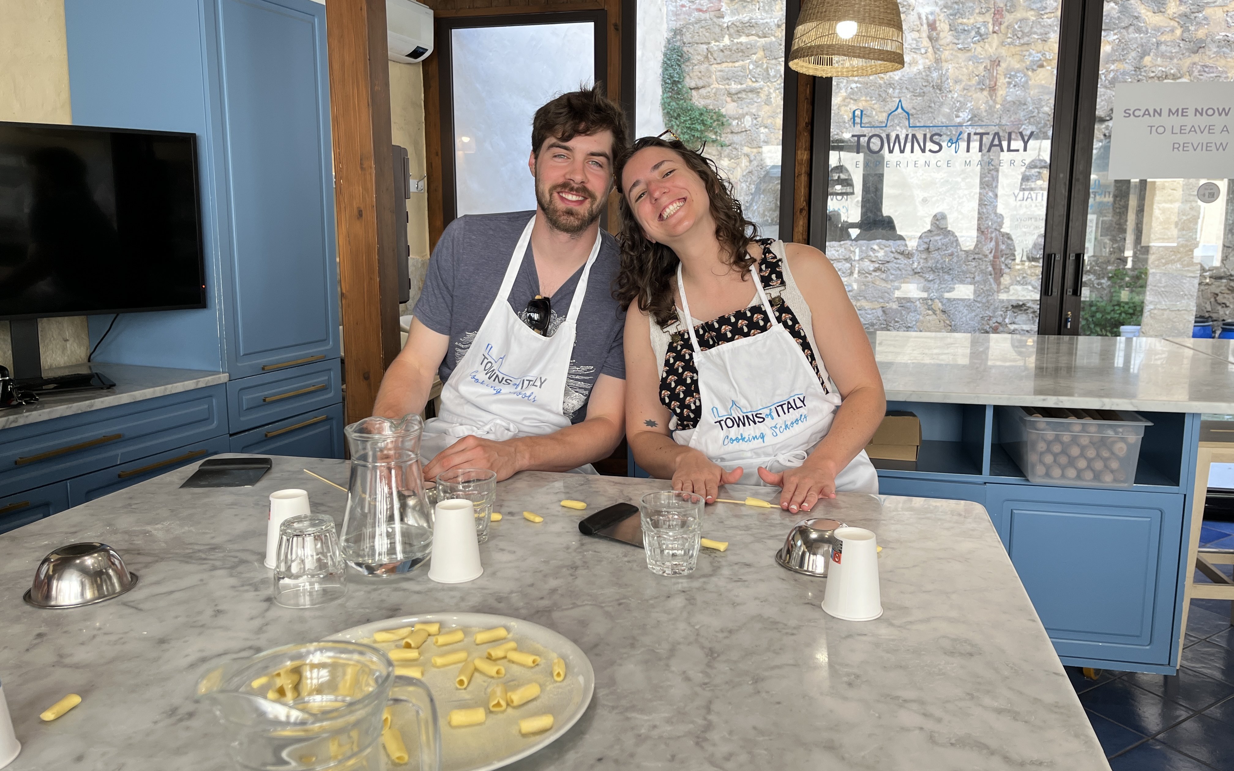 Couple making pasta during Palermo Market Tour and Cooking Class in Italy.