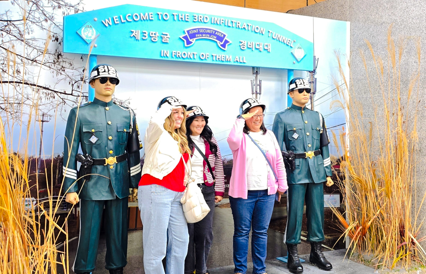 Women posing with statues at 3rd Infiltration Tunnel entrance, Seoul to DMZ tour, South Korea.