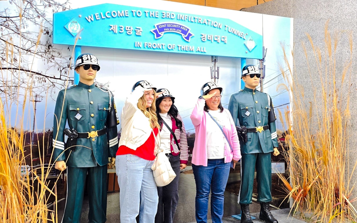 Women posing with statues at 3rd Infiltration Tunnel entrance, Seoul to DMZ tour, South Korea.