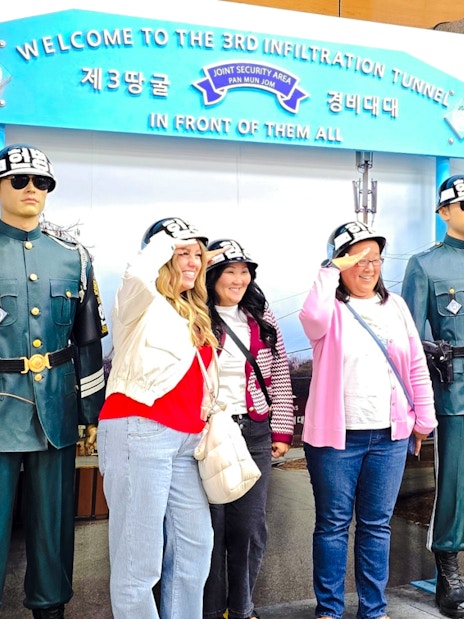 Women posing with statues at 3rd Infiltration Tunnel entrance, Seoul to DMZ tour, South Korea.