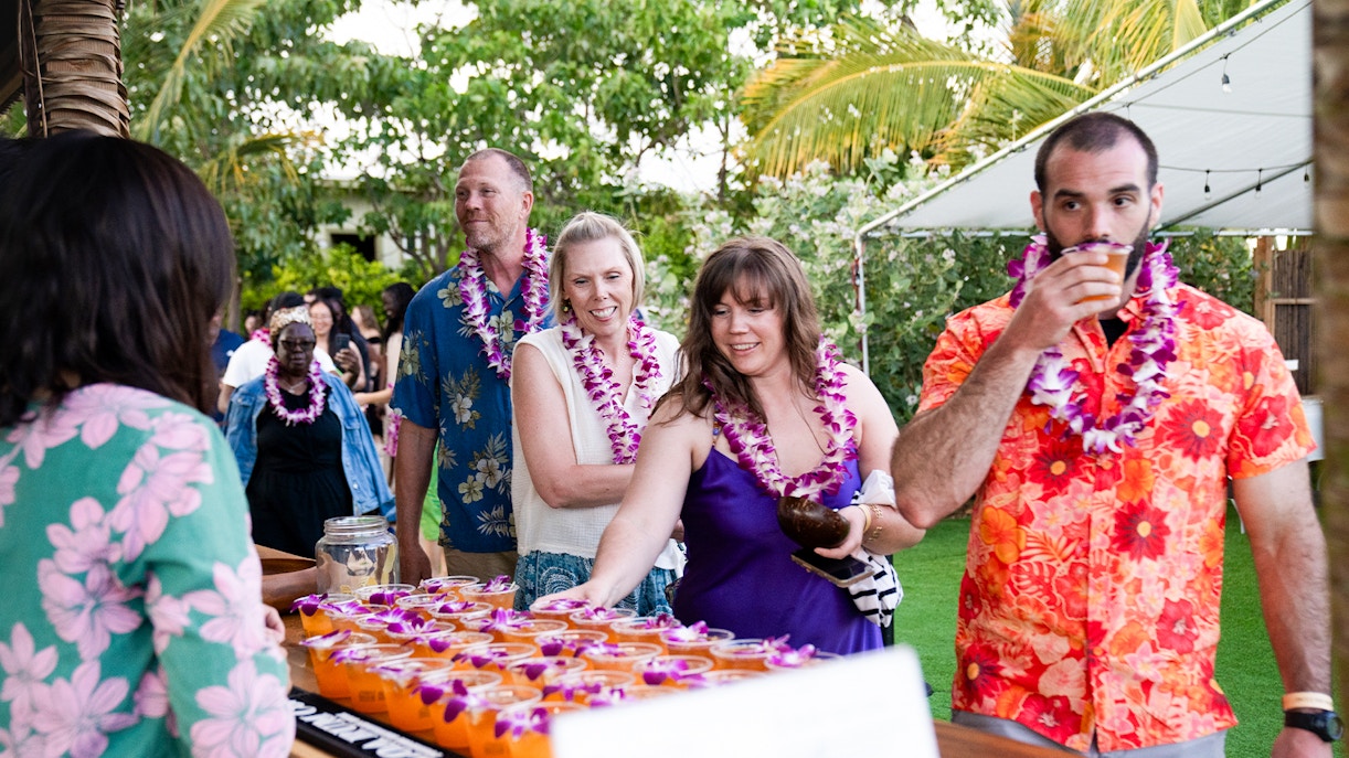 Guests receiving welcome drinks at Mauka Warriors Luau entrance.