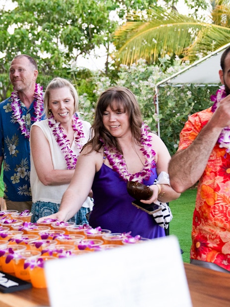Guests receiving welcome drinks at Mauka Warriors Luau entrance.