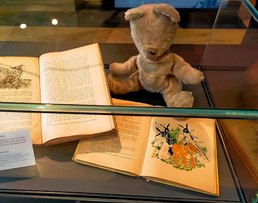 Burned toy and children's books displayed at D-Day Normandy museum exhibit.