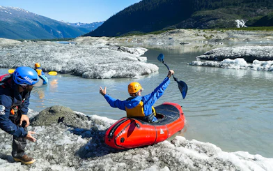 Kayaker launching from icy shore during Norris Adventure tour.