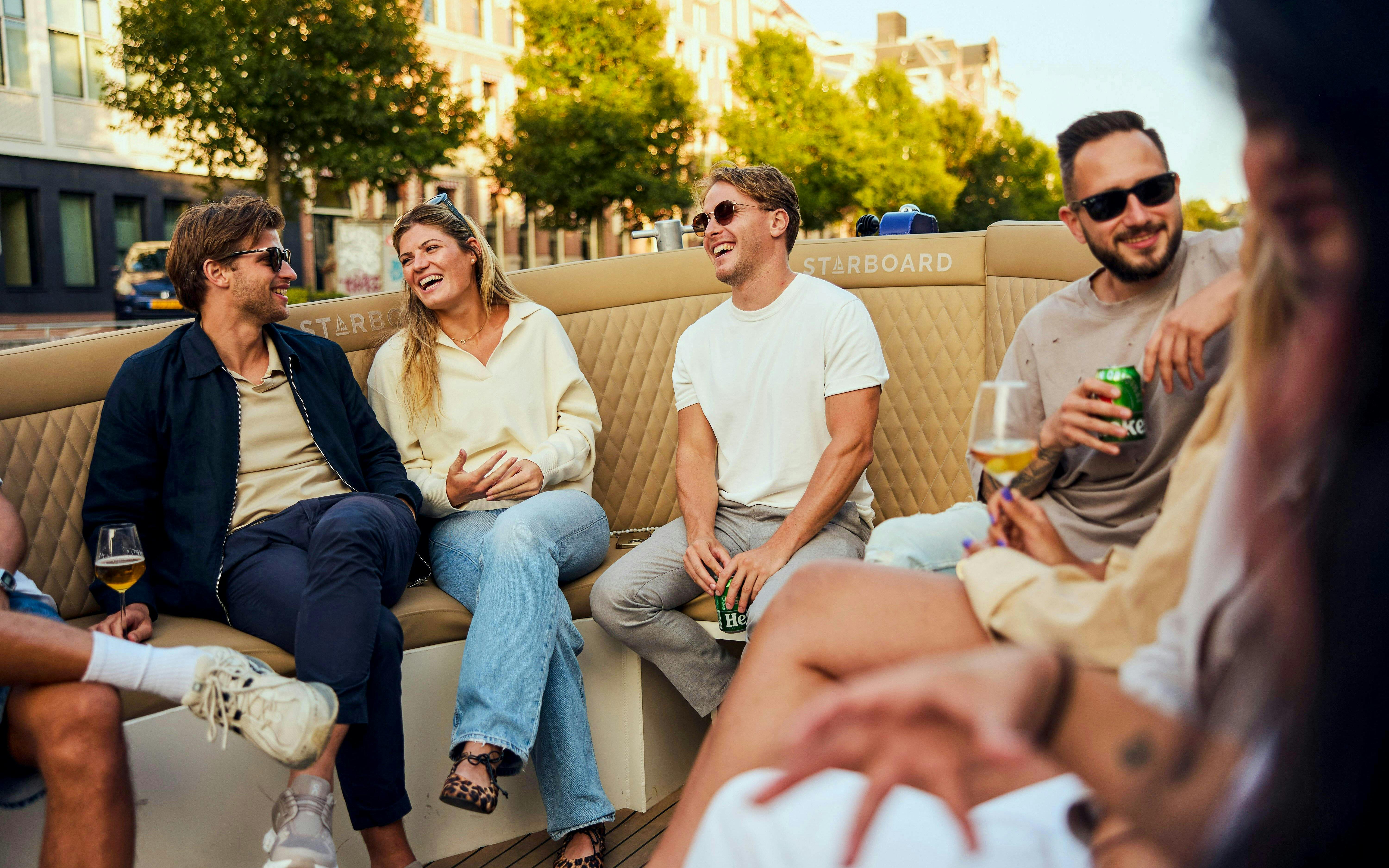 Guests enjoying drinks on a canal cruise in Amsterdam.