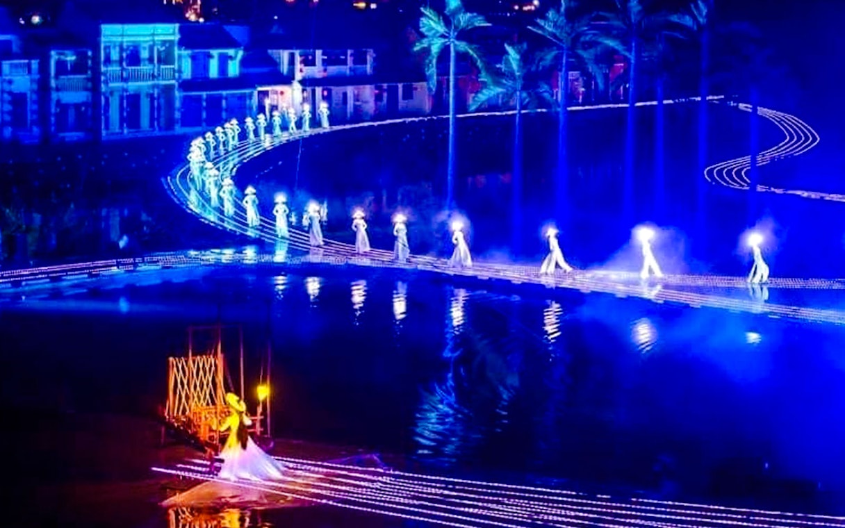 Performers in illuminated costumes on stage at Hoi An Memories Show, Vietnam.