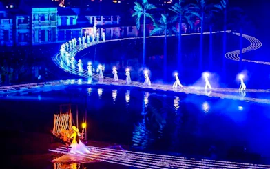 Performers in illuminated costumes on stage at Hoi An Memories Show, Vietnam.