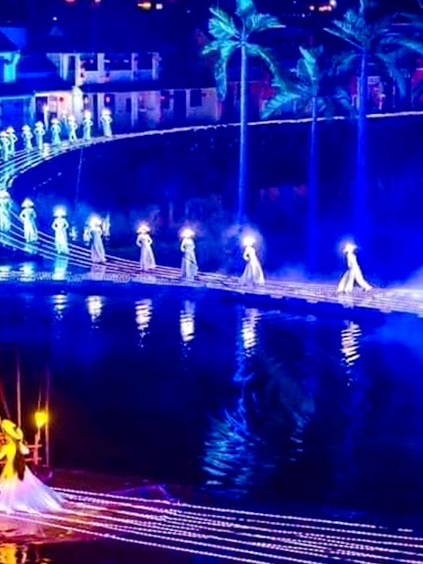 Performers in illuminated costumes on stage at Hoi An Memories Show, Vietnam.