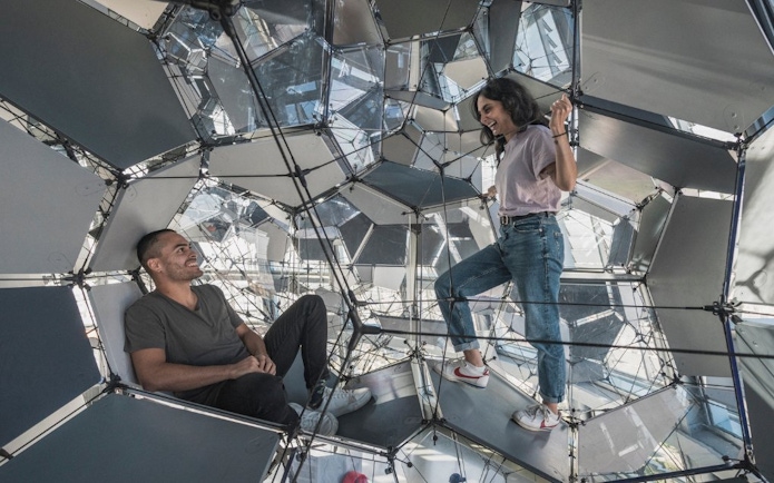 Visitors exploring geometric structure inside Glories Skyline Tower, Barcelona.