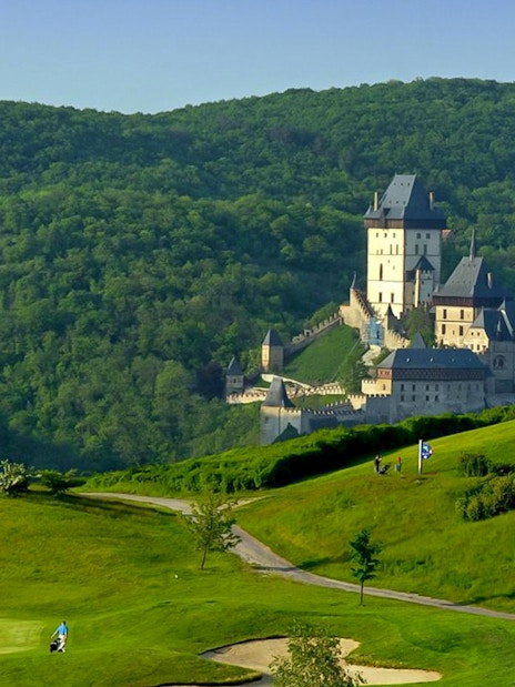Karlstejn Castle surrounded by lush green hills in the Czech Republic.