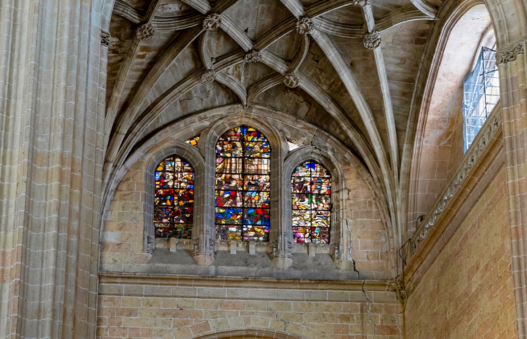 Stained glass windows inside Segovia Cathedral, showcasing intricate designs.