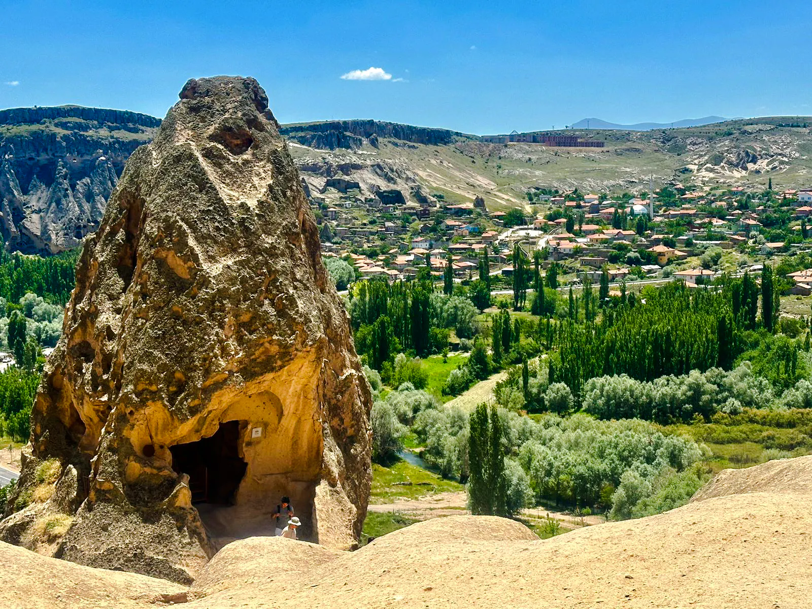 Rock formation with cave entrance overlooking Cappadocia landscape on Green Tour.