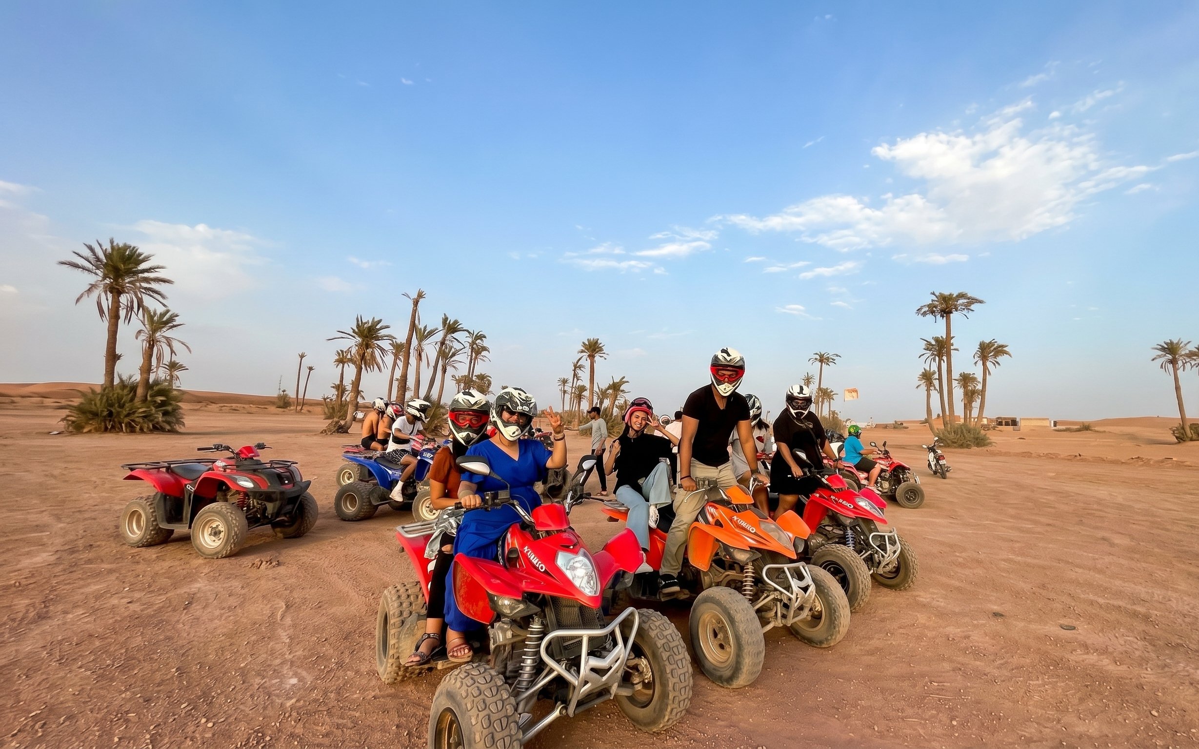 Group on quad bikes in Marrakech palm grove desert.