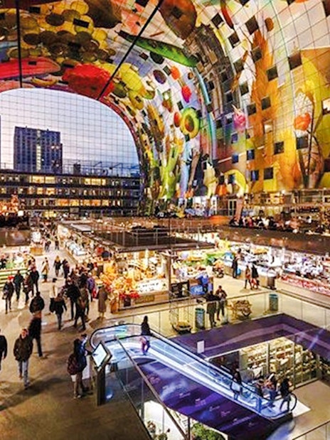 Interior view of Market Hall in Rotterdam with vibrant ceiling art and bustling food stalls.