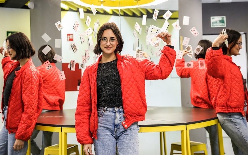 Person holding playing cards in front of mirrors at the Museum of Illusions.