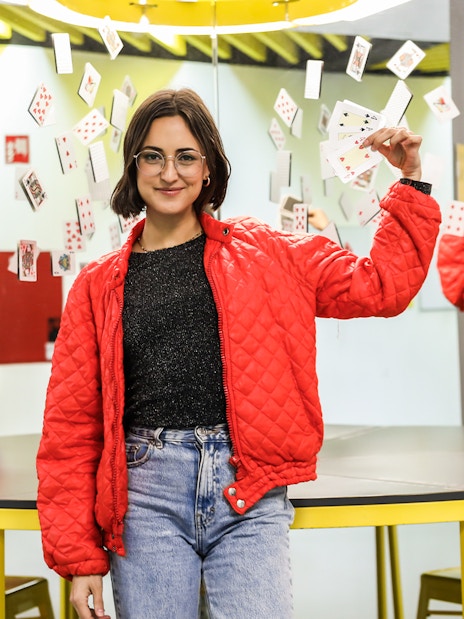 Person holding playing cards in front of mirrors at the Museum of Illusions.